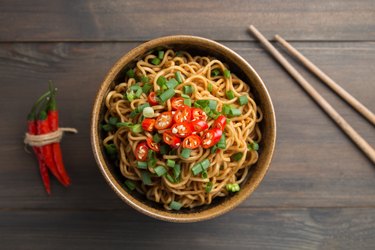Top view of a bowl of spicy ramen noodles with pepper
