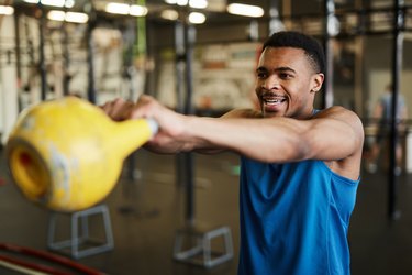 man swinging kettlebell for benefits of strength training
