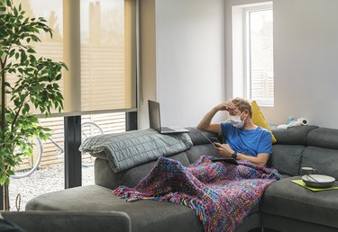 Man in self isolation on the sofa with COVID-19
