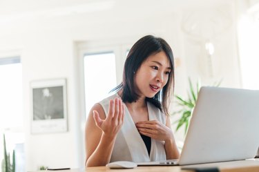 Young woman doing remote job interview on video conference using laptop at home