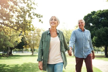 A healthy older couple walking together in a park