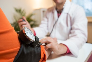 Senior woman getting low blood pressure checked by doctor