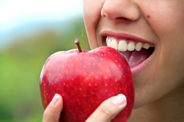 A woman eating an apple high in quercetin, as a natural remedy for allergies
