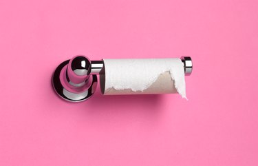 toilet roll that has run out of paper on pink background