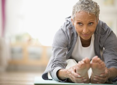Older adult doing yoga on a mat in the morning