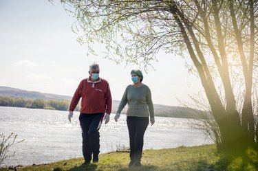older adults walking outside for exercise to reduce blood pressure outside with face masks